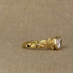 Side view showcasing the 18K gold hallmark stamp inside the botanical bezel diamond band.