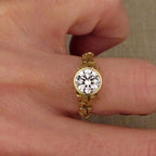 Front top view on finger showing brilliant sparkle of 2 CT round lab diamond in yellow gold bezel.