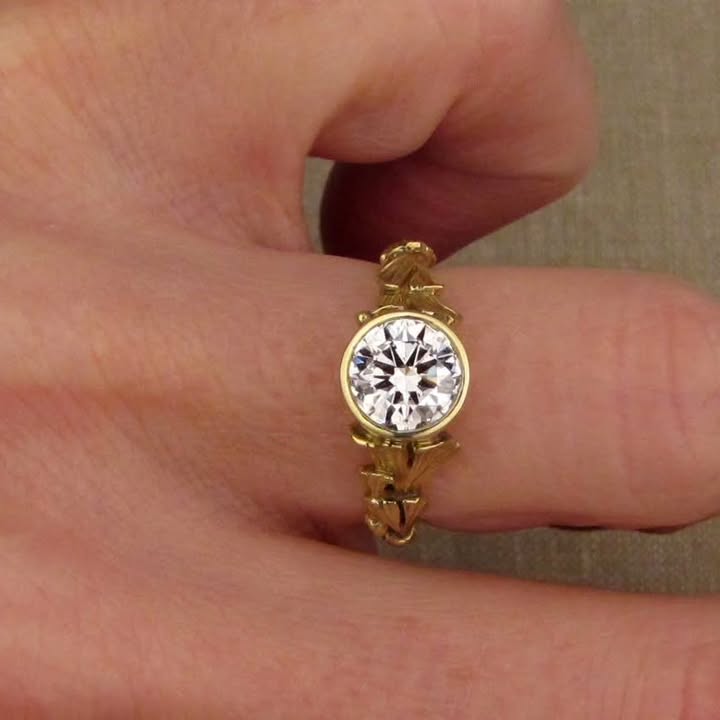 Front top view on finger showing brilliant sparkle of 2 CT round lab diamond in yellow gold bezel.