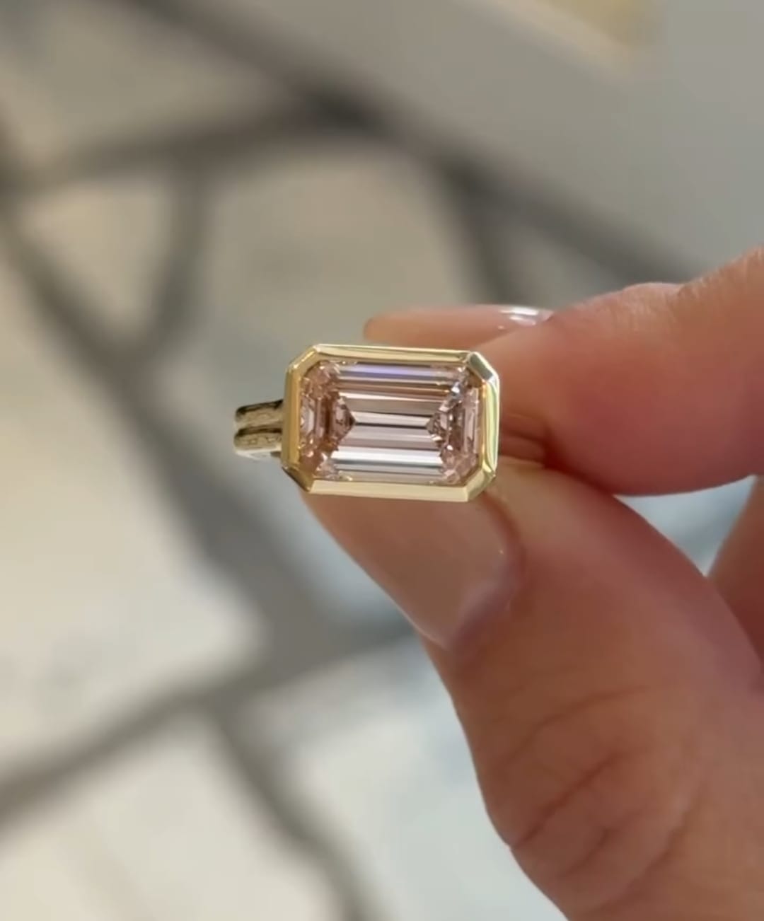 Front view of 3ct pink emerald cut lab diamond featuring step cuts and full protective gold bezel.
