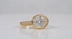 Horizontal 3 CT oval lab diamond ring with milgrain pavé accent band in yellow gold.