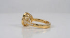 Detailed profile of yellow gold pavé diamond band with milgrain edges on bezel set oval ring.