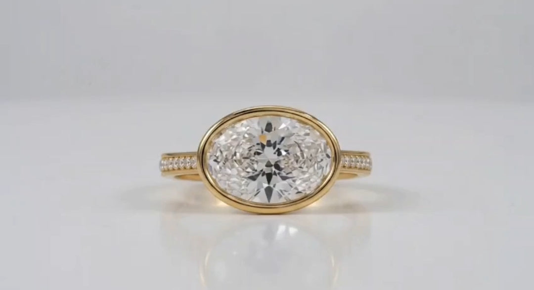 Straight-on front view of 3 CT horizontal oval lab diamond ring in protective bezel setting.
