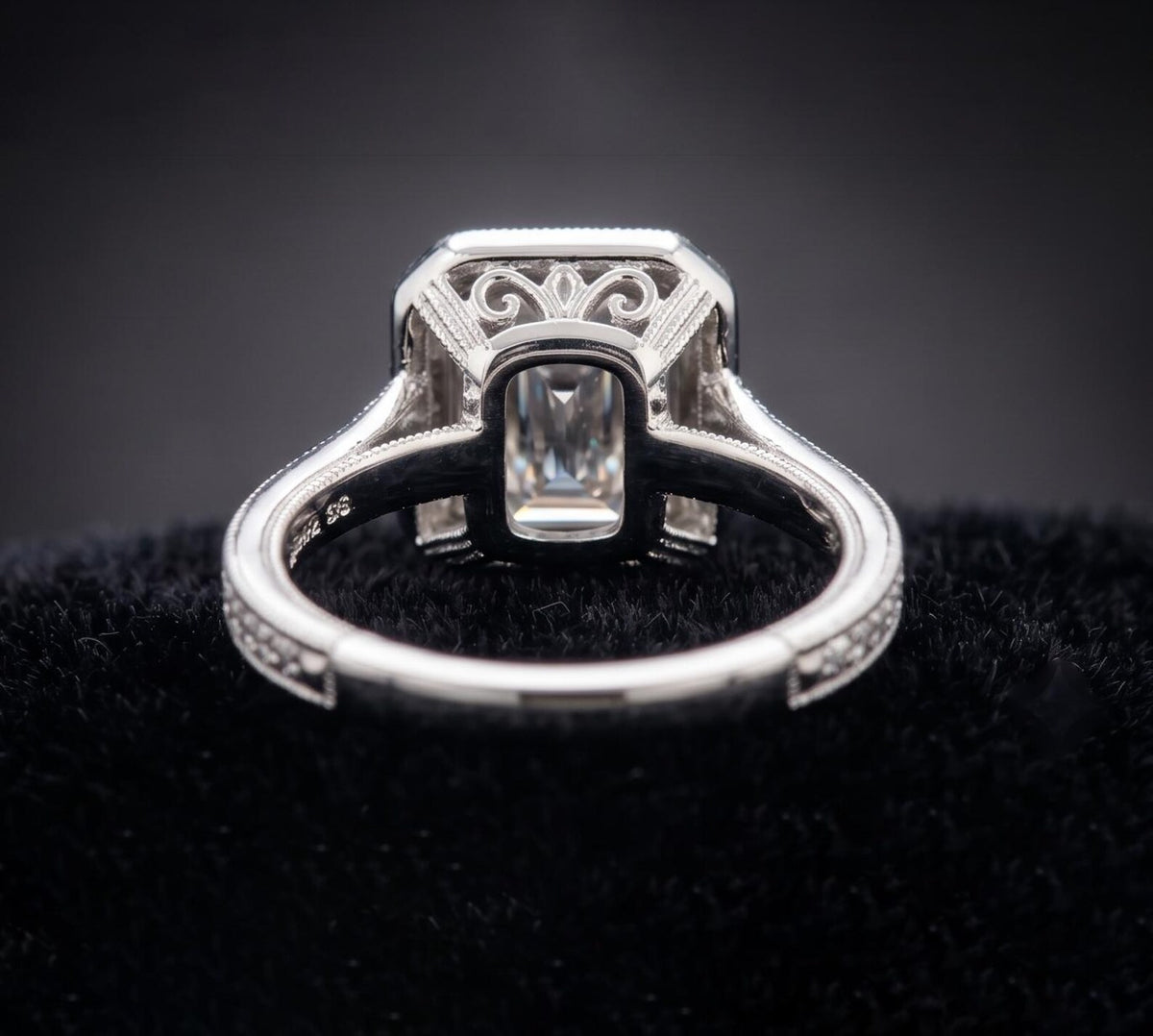 Underside view of 3 CT emerald cut lab grown diamond vintage ring highlighting open gallery and scroll filigree work.