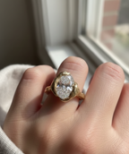 Top view on hand of 4 carat oval cut lab grown diamond in sculptural yellow gold bezel setting