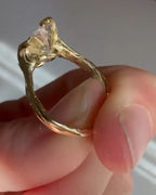 Three-quarter view showing textured bark-like yellow gold band of 4ct oval diamond ring