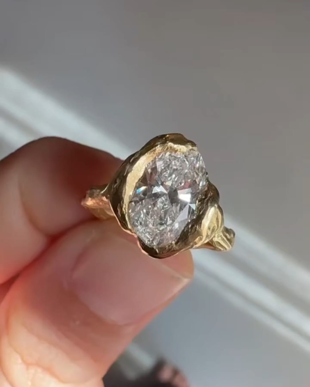 Close-up view of 4ct oval cut lab grown diamond set in molten yellow gold