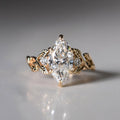 Front view of 3 carat marquise cut lab grown diamond engagement ring with yellow gold leaf band