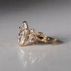 Side profile of marquise lab diamond ring showing gold leaf vine shank and pave basket