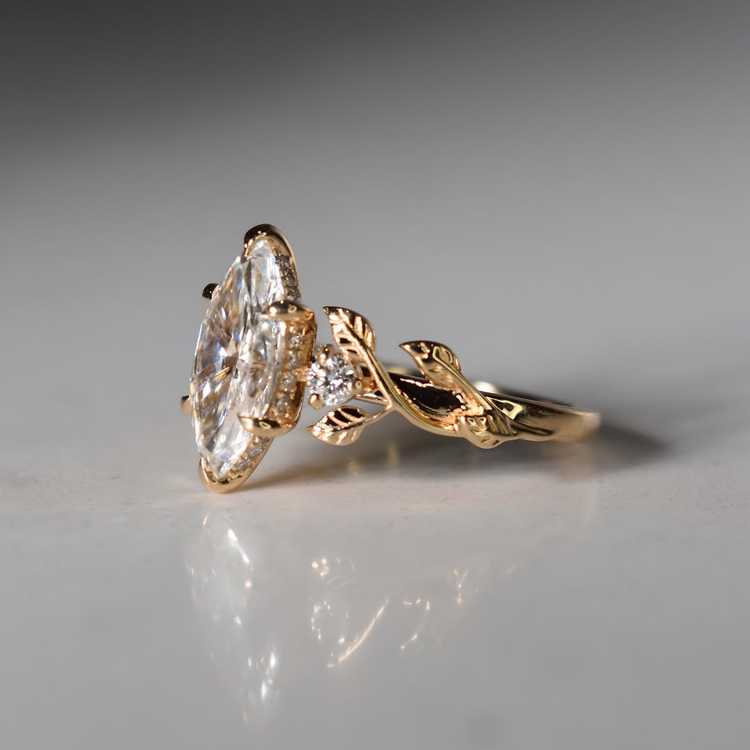 Side profile of marquise lab diamond ring showing gold leaf vine shank and pave basket