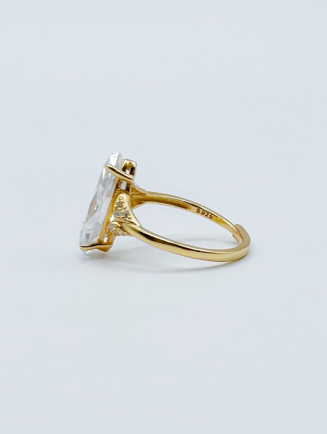 Side profile view of 3 CT marquise lab diamond engagement ring showing high basket setting and S925 hallmark stamp.