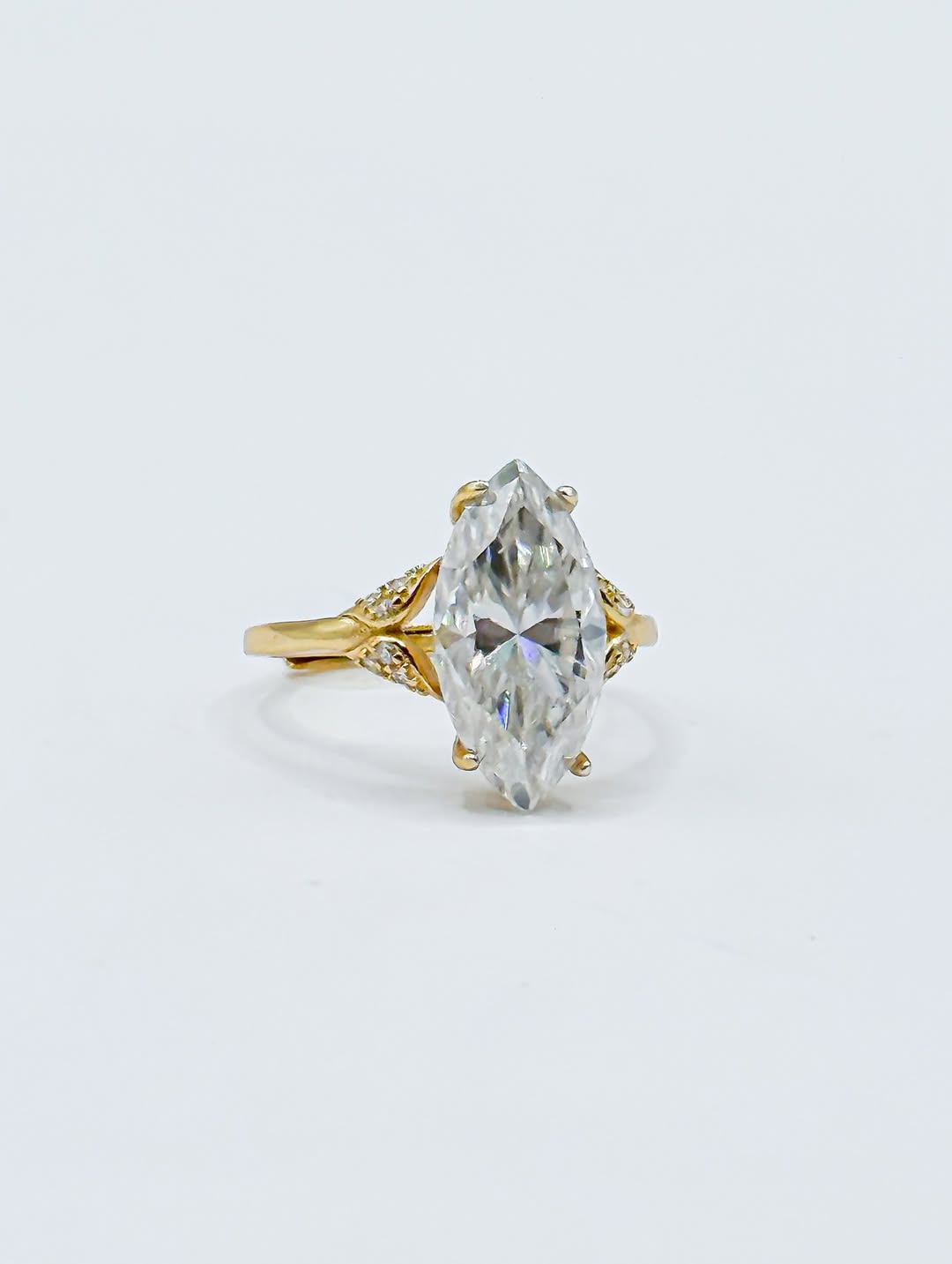 Three-quarter studio perspective of 3 CT marquise cut lab grown diamond ring highlighting leaf-shaped pave side accents.