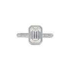 Top perspective of white gold 3 CT emerald cut lab grown diamond bezel ring with hand-carved vintage pattern.