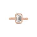 Top view of rose gold 3 CT emerald cut lab diamond ring with protective bezel setting and engraved detailing.
