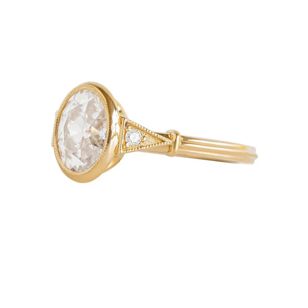 Top view of yellow gold 2 CT oval cut lab diamond engagement ring with milgrain bezel and side accents.