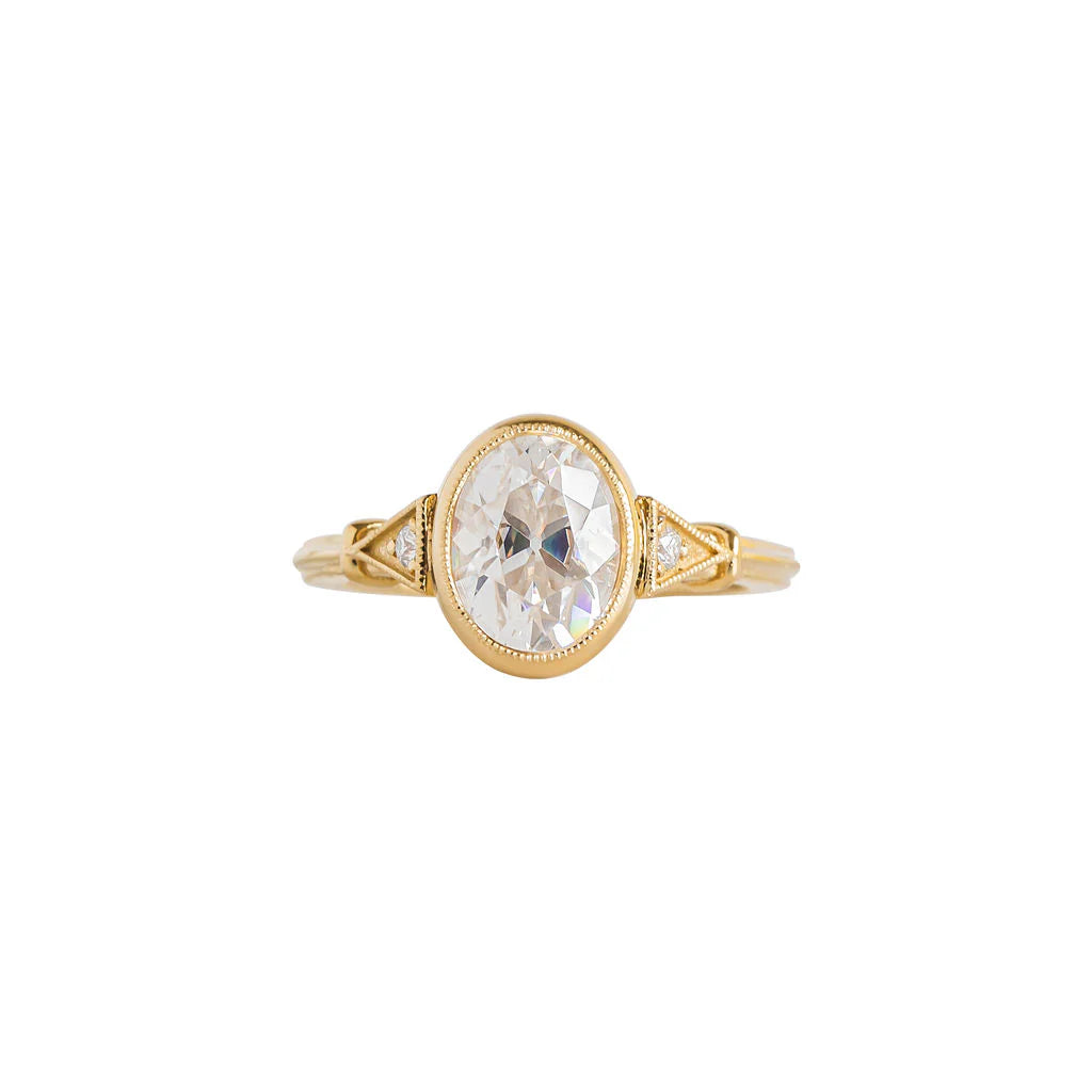 Top view of yellow gold 2 CT oval cut lab diamond engagement ring with milgrain bezel and side accents.