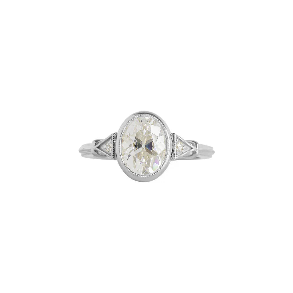Top view of white gold 2 CT oval cut lab grown diamond ring with protective milgrain bezel setting.