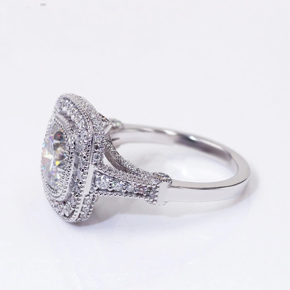 Three-quarter side angle of 2 carat cushion cut lab diamond ring with split shank and vintage milgrain halo.