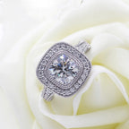 Cushion cut lab grown diamond double halo ring displayed on a white rose petal backdrop