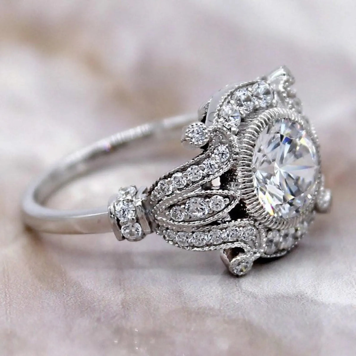 Close-up side angle highlighting coin-edge milgrain bezel framing and diamond-paved scrollwork on round lab diamond ring.