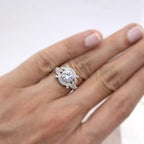 On-hand perspective showcasing round lab diamond center stone and detailed art deco leaf shoulder design.