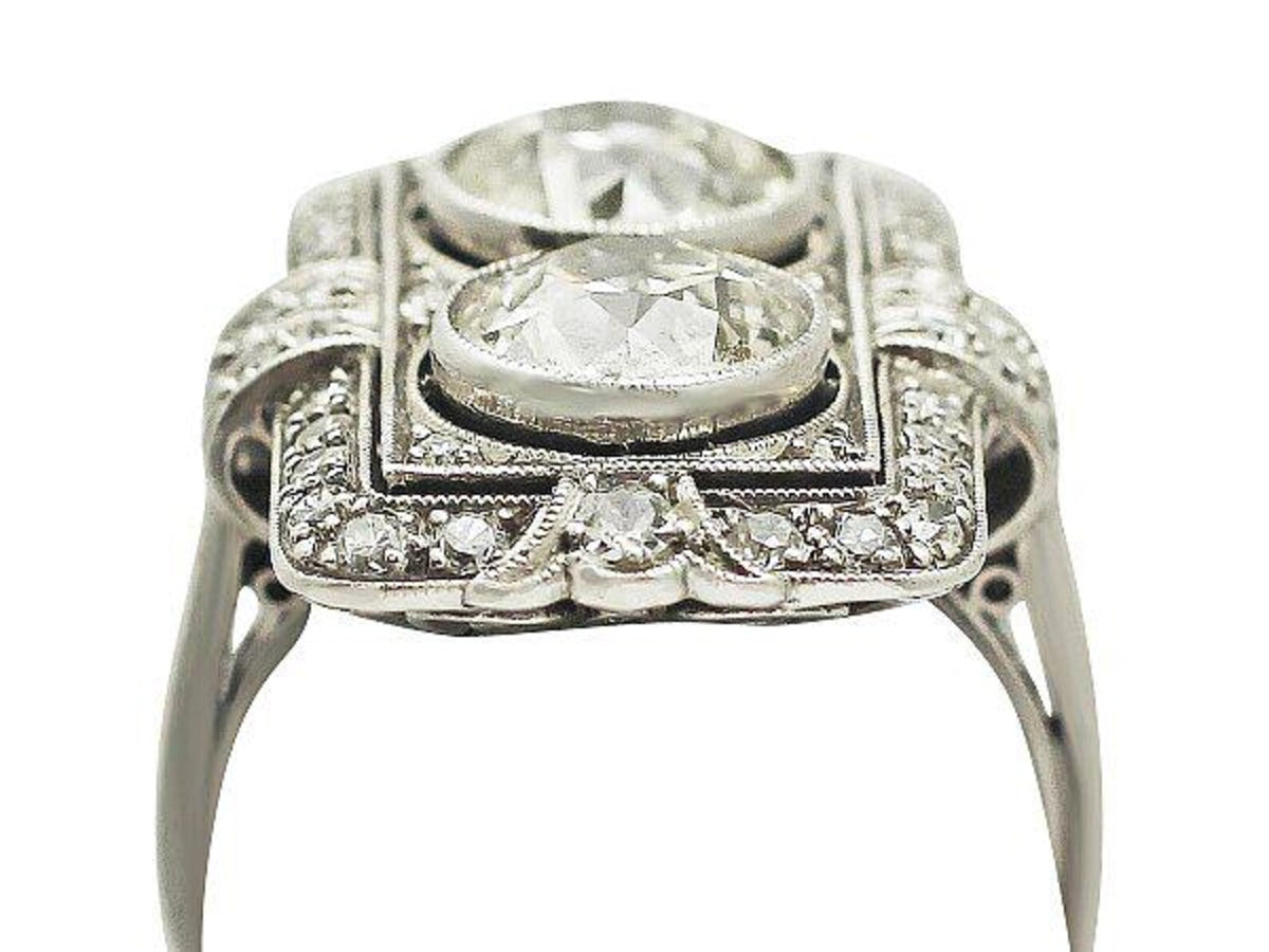 Low-angle side view of vintage Art Deco two-stone lab diamond plaque ring showing raised bezels and milgrain edging.