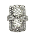 Top-down studio shot of Art Deco two-stone round lab grown diamond shield ring with geometric pavé frame.