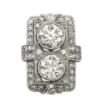 Top-down studio shot of Art Deco two-stone round lab grown diamond shield ring with geometric pavé frame.