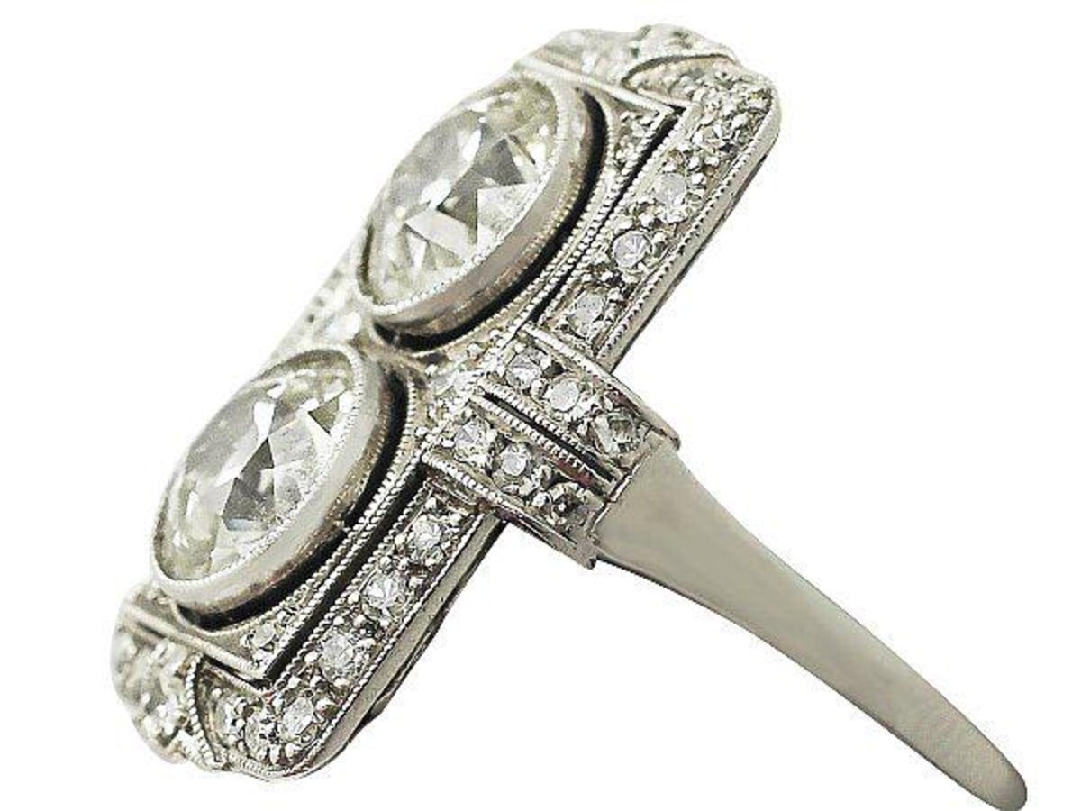 Three-quarter side angle showing slim band transition and micro-pavé shoulders on two-stone Art Deco lab diamond ring.
