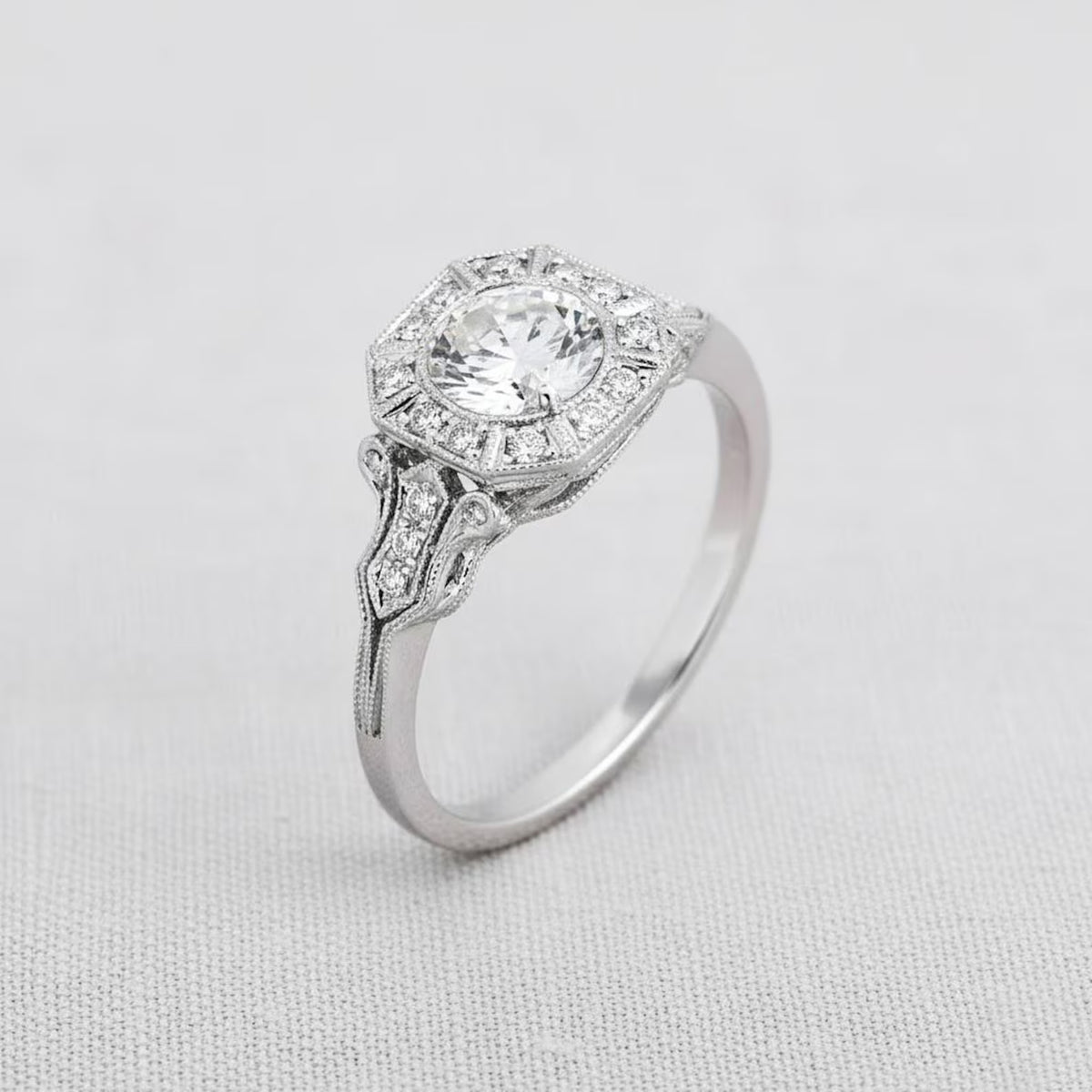 Three-quarter angle shot of 2 CT round lab diamond engagement ring featuring an Art Deco octagonal halo on fabric