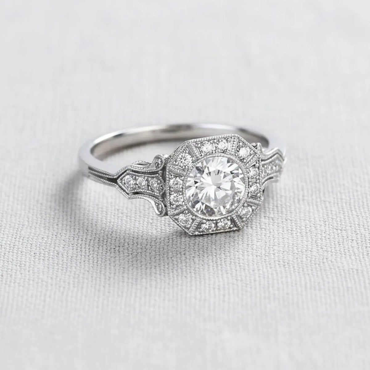 Side profile angle showing milgrain chevron shoulders on a white gold round lab diamond engagement ring.