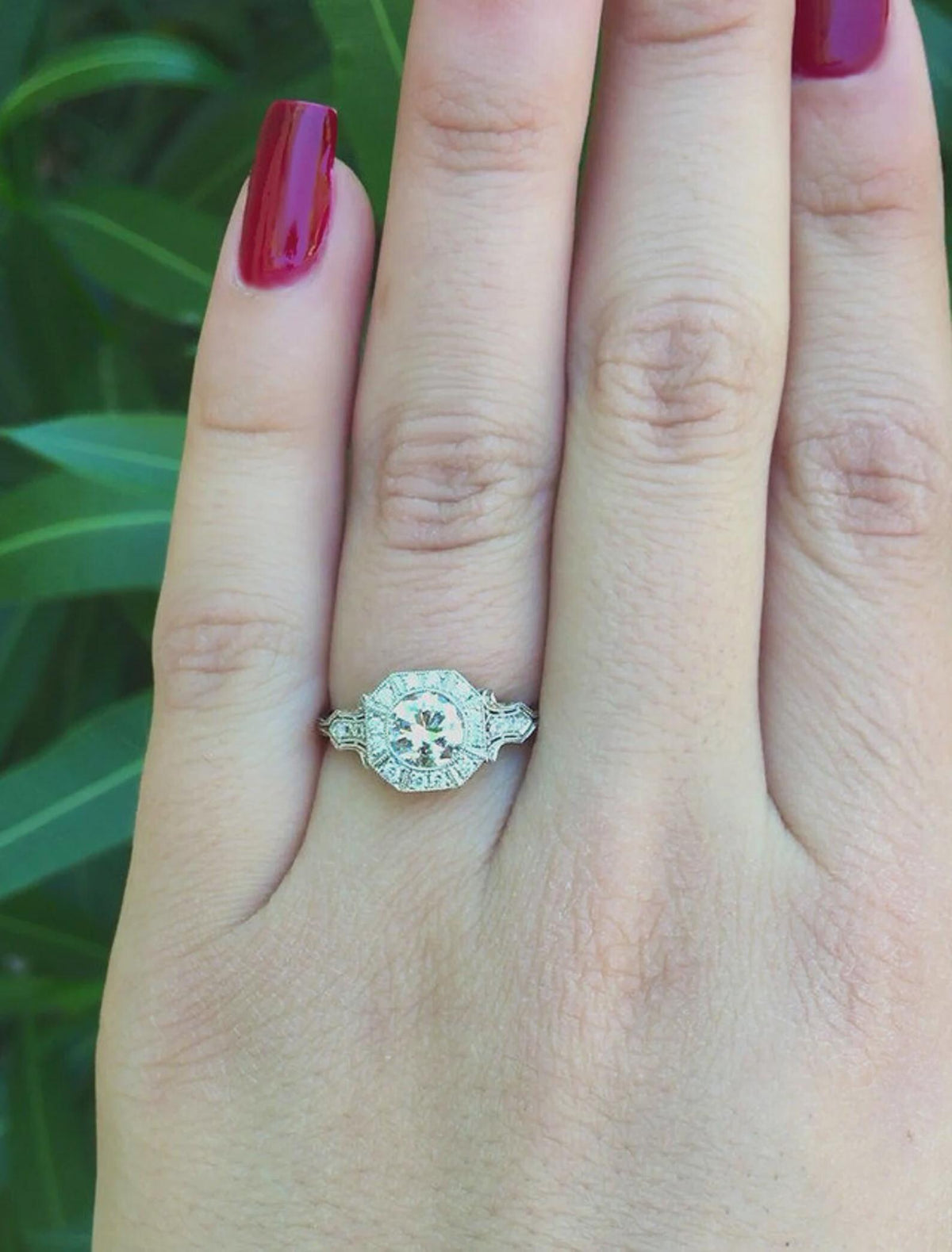 Top-down view on hand displaying finger coverage of an octagonal halo 2 CT round lab diamond ring.