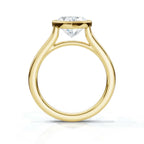 Direct profile view of a yellow gold heart-shaped diamond engagement ring showing the full circular band and elevated bezel structure.