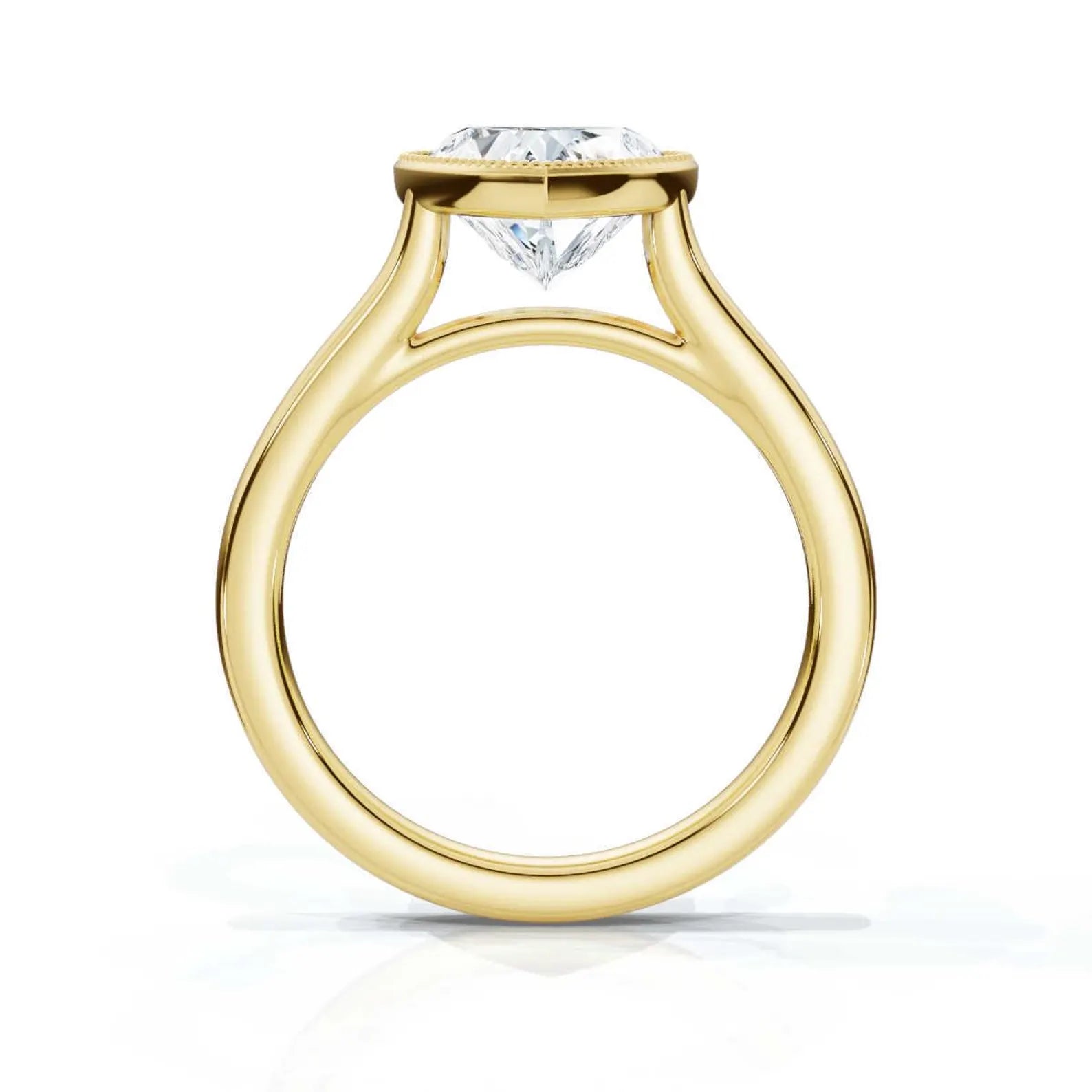 Direct profile view of a yellow gold heart-shaped diamond engagement ring showing the full circular band and elevated bezel structure.