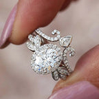 Close-up finger view showing oval cut lab diamond halo ring paired with pear-accented tiara band.