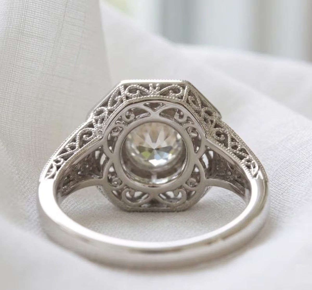 Underside openwork gallery view of a 2 CT round lab grown diamond engagement ring showing intricate filigree lattice detail.