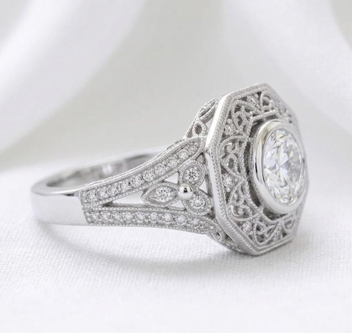Perspective angle showing the octagonal halo framing a 2 CT round lab diamond with filigree and shoulder side stones.