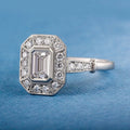 Close-up of a 2 CT emerald cut lab grown diamond showing hall-of-mirrors step cuts set in white gold with milgrain halo.