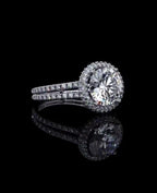 High-angle perspective of a 3 Carat round cut lab diamond halo ring resting on a reflective black background.