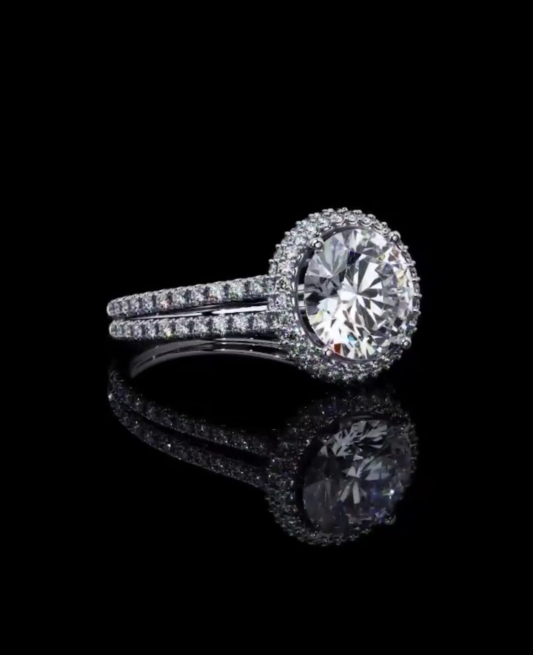 High-angle perspective of a 3 Carat round cut lab diamond halo ring resting on a reflective black background.
