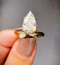 Close-up shot highlighting the V-prong tip and asymmetrical bypass styling of a 3 CT pear cut lab grown diamond ring.