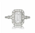 Top-down view of a 2 carat emerald cut lab grown diamond engagement ring with a vintage diamond halo.