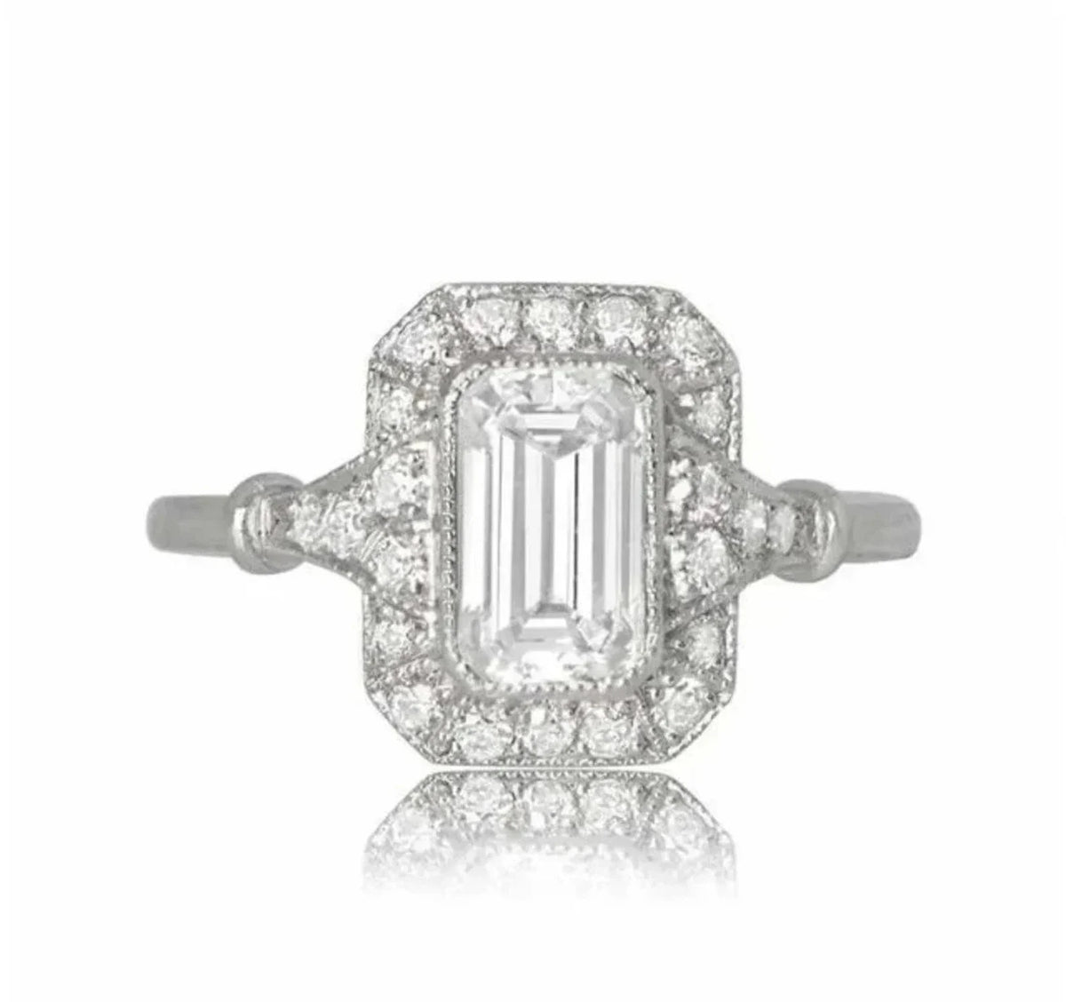 Top-down view of a 2 carat emerald cut lab grown diamond engagement ring with a vintage diamond halo.