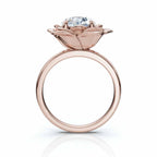 Overhead view of a round brilliant cut lab grown diamond surrounded by rose gold flower petals.