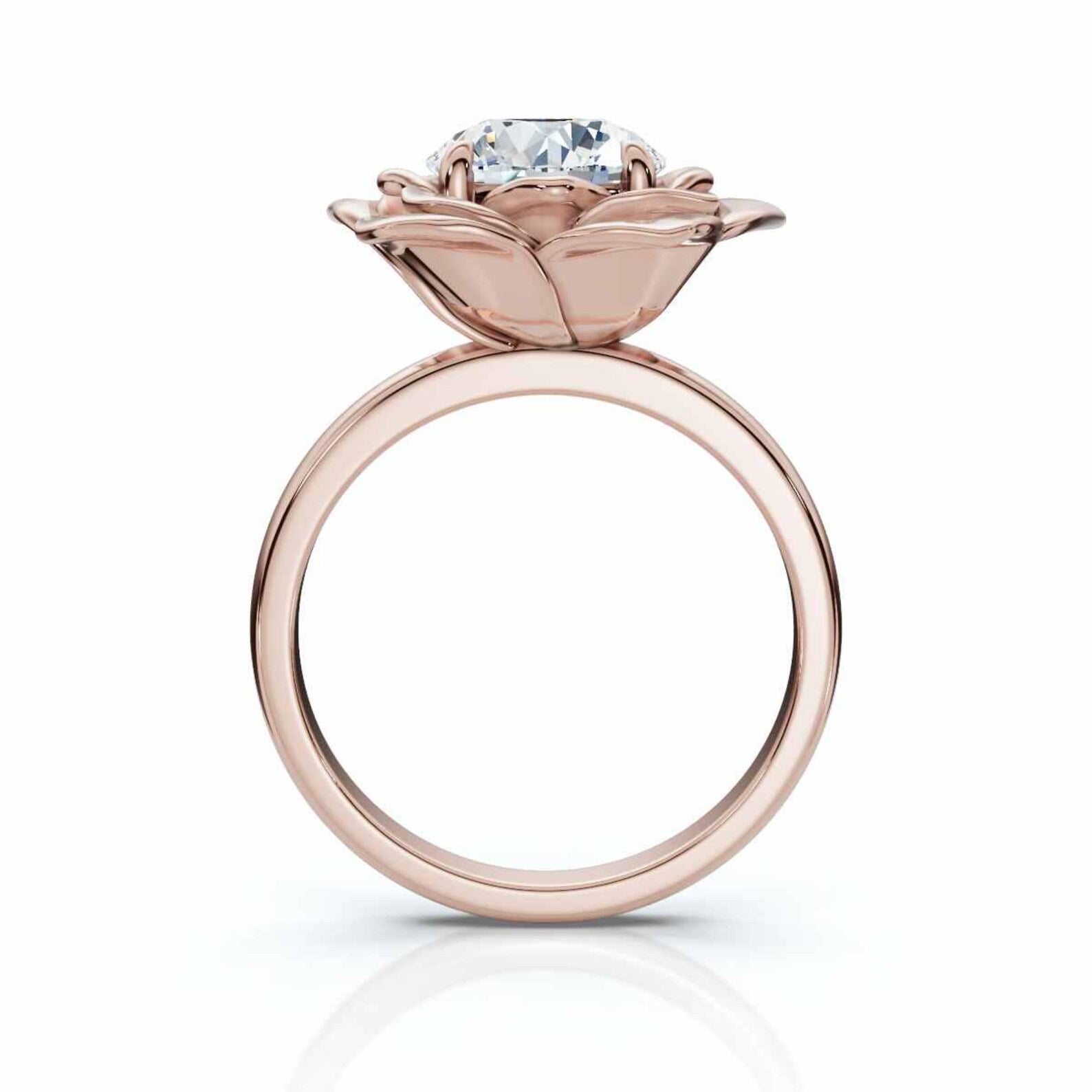 Overhead view of a round brilliant cut lab grown diamond surrounded by rose gold flower petals.