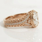 Side profile perspective showing botanical leaf carvings, pave diamond accent band, and bezel halo on a 14K rose gold vintage ring.