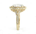 Top-down view of a 3 CT oval cut lab grown diamond engagement ring in yellow gold with a scalloped halo and milgrain split band.