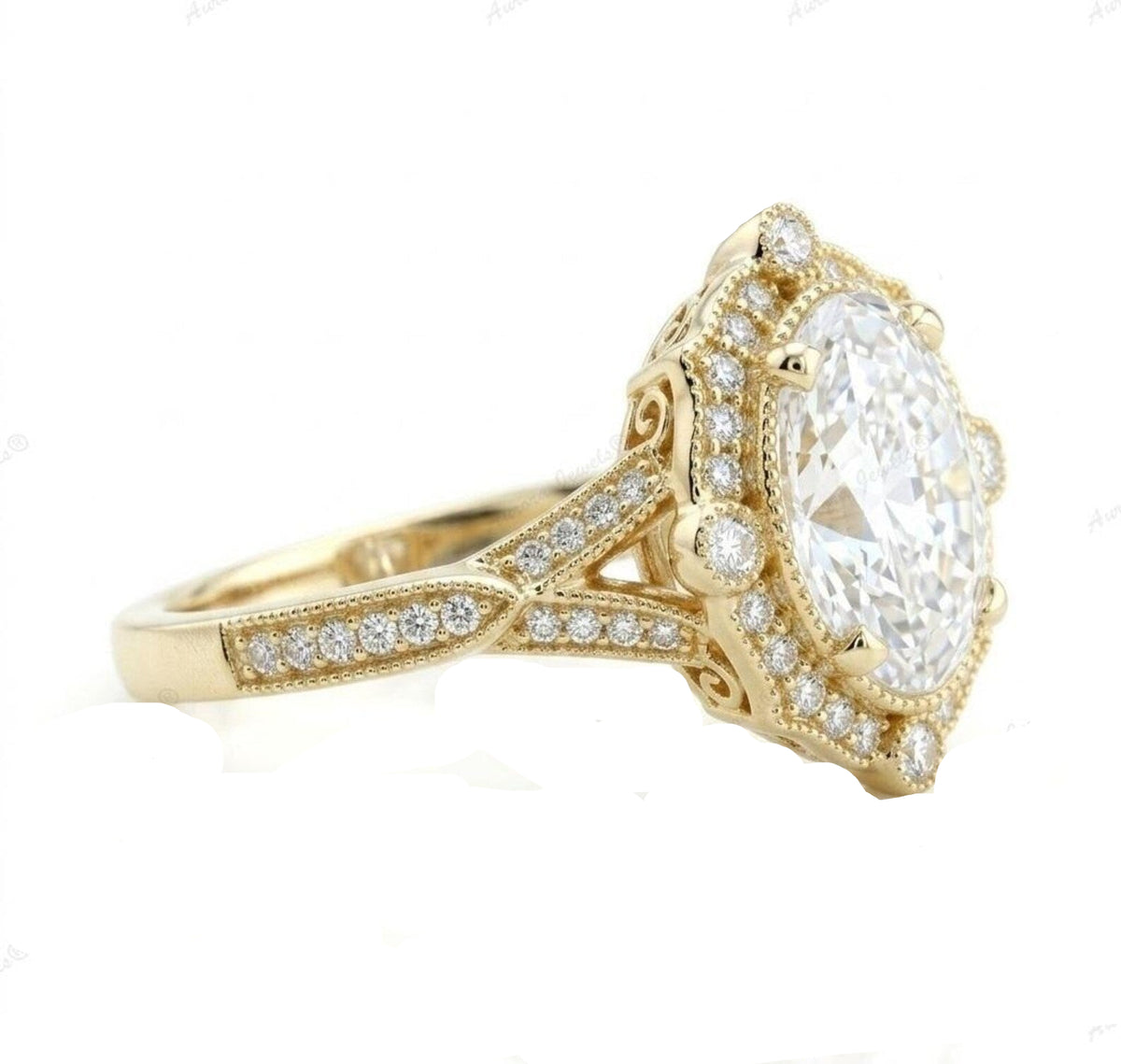 Side profile shot showing the scrollwork filigree undergallery and pave split shank of a yellow gold oval diamond ring.