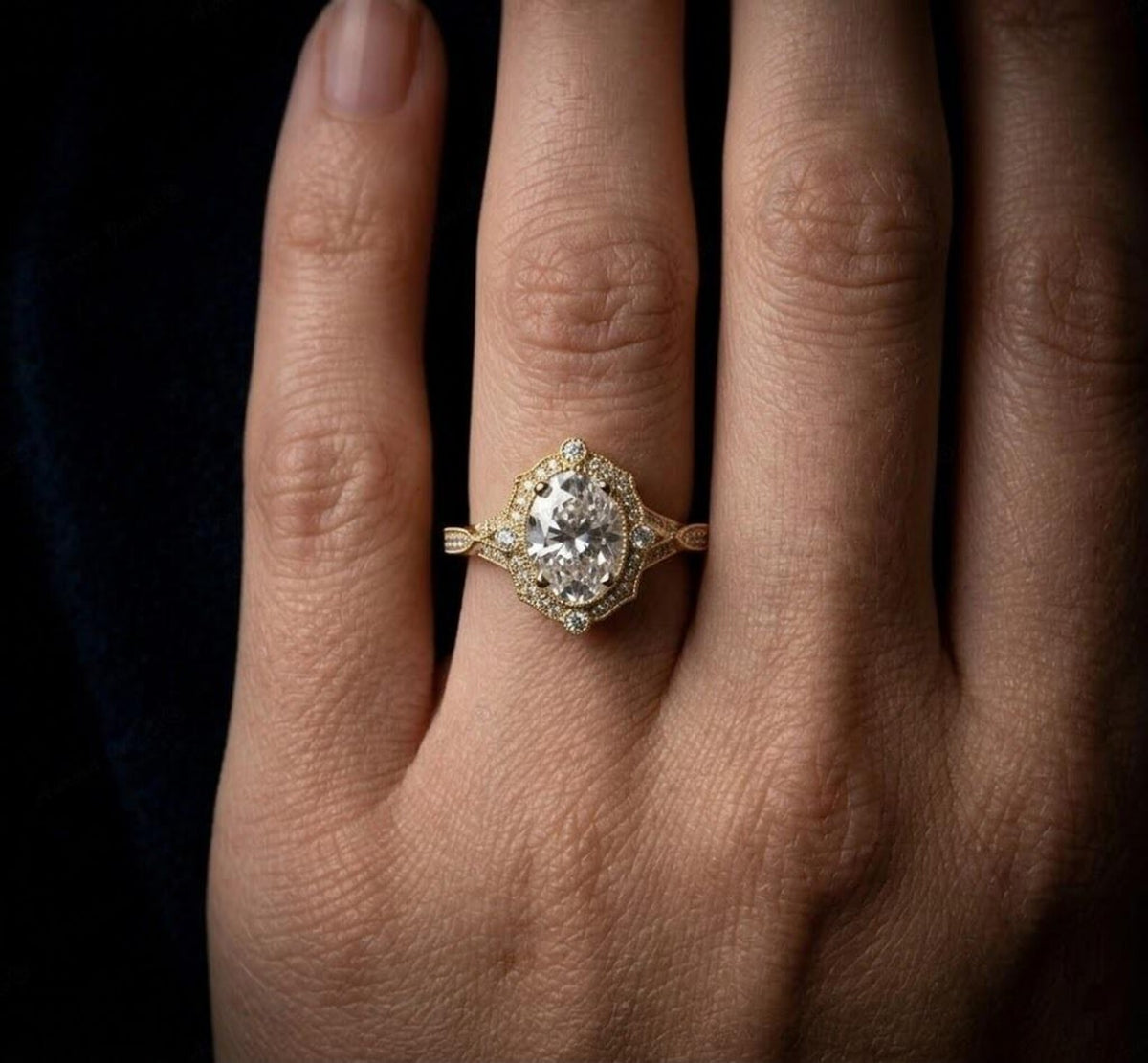 On-hand view of a 3 carat oval lab grown diamond scalloped vintage engagement ring in yellow gold.