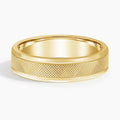 Front view of yellow gold men's wedding ring with knurled textured band and polished trim.